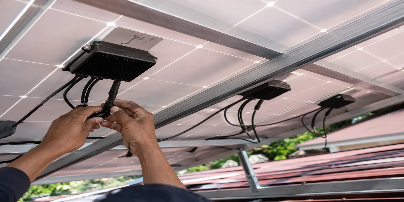 Side-by-side illustration comparing series-wired solar panels, where one shaded panel throttles the whole string, against parallel-wired panels, where a shaded panel only reduces its own output